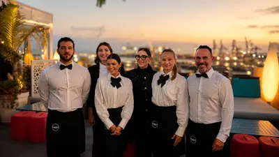 El equipo de Momento en una terraza al atardecer, en uniforme de servicio