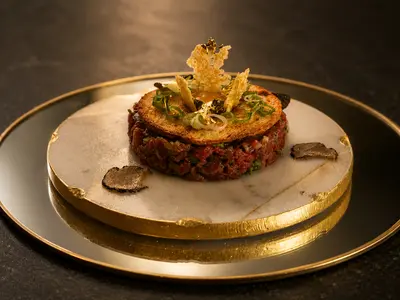 Tartar de ternera con láminas de trufa sobre plato dorado