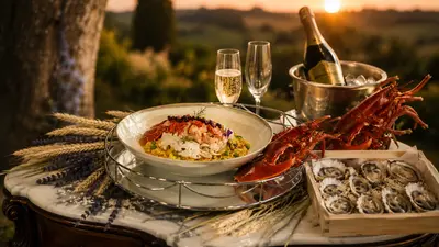 Bogavante, ostras y champán servidos al atardecer sobre una mesa de mármol